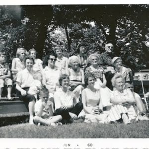 An old photograph of a family gathering that includes family friends “Uncle Arthur and Aunt Lucy” in the top right corner. Helen, age 11, is third from the left in the top row. Her mother is just below, holding her baby brother.
